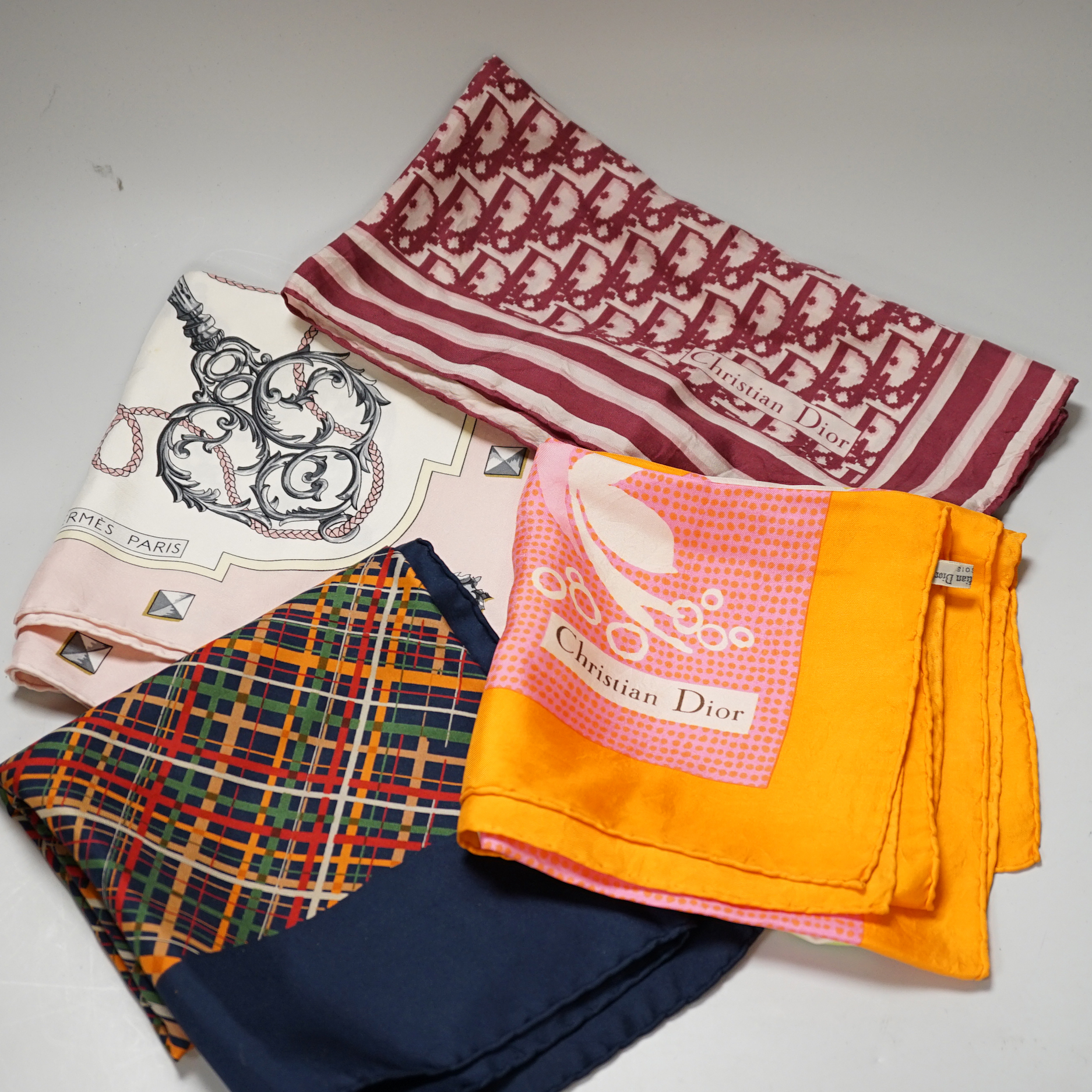 A Hermes, Paris silk scarf “Les Cles Bordeaux” with pink border and three Christian Dior silk scarves